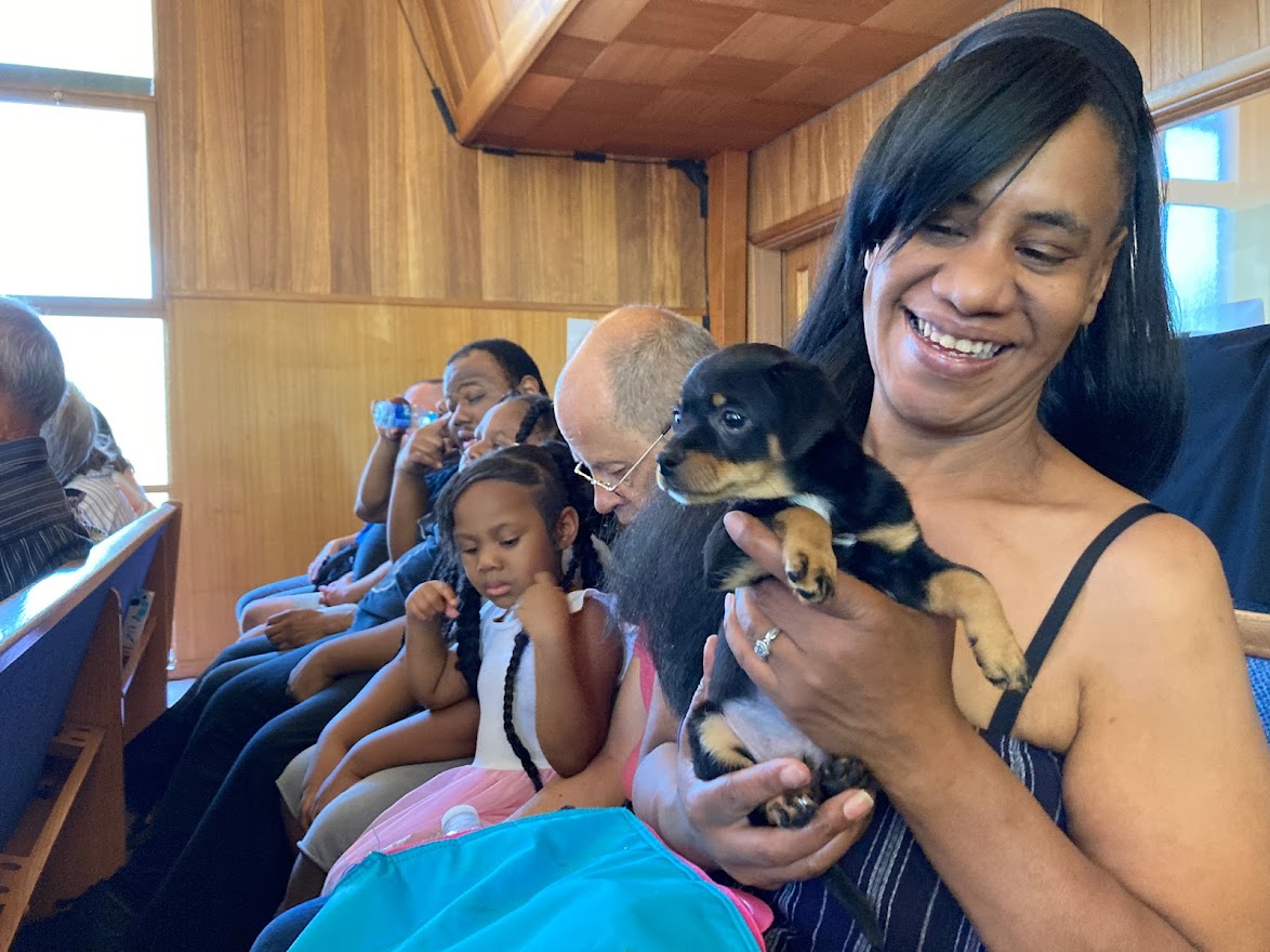 women with children and puppy at church